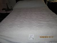 Full view of vintage Bates chenille bedspread laid over bed, showing overall size and pattern in cream color.