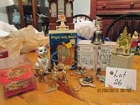 Photo showing the gold-tone cat figurine, two Hutshshenreather Christmas bells, old organ decoration with angel, small gold-tone angels, and various bird-shaped ornaments on table