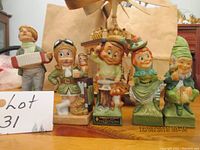 Front view of five colorful vintage liquor bottles shaped as figurines including accordion man music box figurine