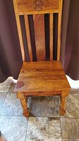 Oak wooden chair showing full front view with carved star detail on top of backrest, seat, and turned front legs.