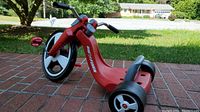 Big Flyer toddler tricycle, red plastic frame, three wheels, suitable for ages 24 months to 3 years.
