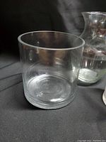 Clear glass vase with short height and wide diameter, cylindrical shape.