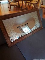 Full view of the rectangular mirror showing the oak wood frame and the etched glass decorative pattern along the edges.