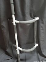 Photo showing the front view of the chin-up bar with padded grips and metal frame against a black backdrop.