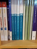 Photo of 5th grade curriculum books including American History, Math, Science, and Language Arts activity books and guides.
