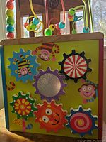 Side of cube with seven colorful interlocking gears and monkey illustrations
