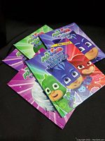 Five PJ Masks hardback books stacked with covers visible, featuring Catboy, Owlette, and Gekko.