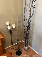 Wide angle of the decorative candle holder, sculpture, and tall vase in corner of room