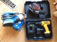 DeWalt cordless drill with battery, charger, and Black & Decker sander shown together.
