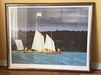 Full view of framed art showing sailboat on water with figures in yellow raincoats, dark land background, and cloudy sky.