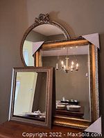 Photo showing all three mirrors stacked together on a wooden surface against a wall, capturing distinct frame styles and sizes.