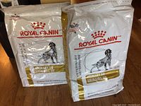 Two unopened 8 kg bags of Royal Canin Veterinary Urinary SO dog food side by side, showing front packaging with logo and dog image.