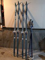 Four Elan cross country skis standing upright showing bindings, tips, and shafts.
