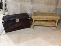Two woven furniture pieces: dark brown storage chest and light tan side table side by side on concrete floor against wall.