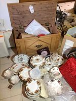 Open solid wood trunk filled with china pieces