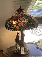 Overall view of lamp lit showing stained glass shade and base