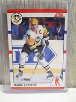 Front side of 1990 Score Mario Lemieux hockey card in protective hard sleeve top loader showing Lemieux in Penguins uniform on ice.