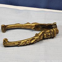 Side view of the solid brass nutcracker showing full character design and handle shaping.