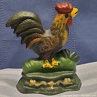 Front view of cast iron rooster door stop showing bright colors and detailed paint.
