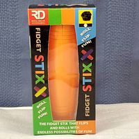 Front view of the box showing the orange Fidget Stix with branding and colorful packaging.