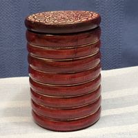 Side view of the round wooden box showing ribbed grooved sides and reddish-brown stain.