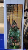 Box label showing product description and features including 10 inch size, green glitter, battery operated LED lights and decorations
