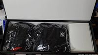 Box containing a pair of black and red heated socks in sealed plastic packaging.