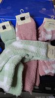 Photo of eight pairs of Aeropostale fuzzy crew socks in pink and green colors with tags attached.