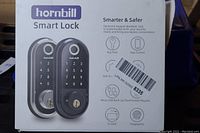 Photo of Hornbill Smart Lock product box showing two locks and features such as keyless entry, app control, anti-theft, micro USB backup, touchscreen keypad, IC card, fingerprint detection