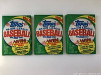 Three 1984 Topps Major League Baseball unopened baseball card packs showing front of packaging with contest and gum details.