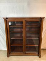 Full front view of wood and glass bookcase with doors closed
