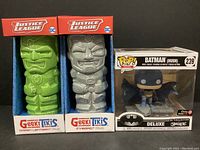 Front view of two Justice League GeekiTikis mugs (Green Lantern and Cyborg) and Funko Pop Batman boxed figurine.