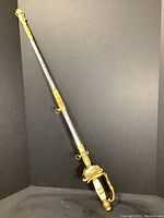 Full length view of sword in scabbard against black background