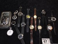 All 14 watches arranged on black background including clip-on, wristwatches, and stopwatch as stated in seller's description.