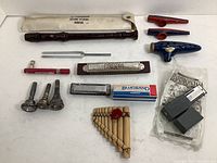Photo showing Yamaha soprano recorder with sleeve, tuning fork, harmonicas, pan flute, kazoos, ocarina, mouthpiece adapters, tuning device, and small boxed items