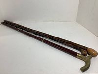 Three walking sticks laid down side by side showing overall length and condition