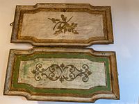 Two rectangular antique Florentine trays, one with floral design and one with scroll motif with green border, showing scratches and wear.