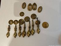 Photo of entire set laid out on white surface showing brass handles, rosettes, and keyhole escutcheons