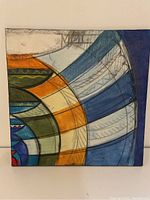 Front view of the square abstract painting with geometric shapes in multiple colors.