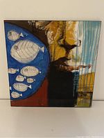 Front view of the square contemporary painting showing abstract fish in blue circle with yellow and black accents.