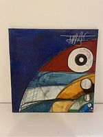 Front view of the painting with colorful abstract shapes and signature in upper right corner.