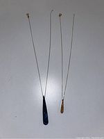 Two druzy quartz necklaces displayed side by side on a flat surface showing overall length and pendants.