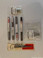 Full lot showing five main items: four tubes of sawblades and one nail set tool in packaging.