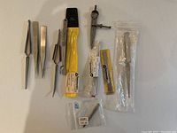 Full overview of all tools including tweezers, compass divider and accessory parts with their packaging.