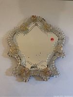 Front view of the Venetian mirror showing decorative cut glass floral motifs and scalloped edges.