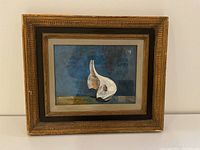 Frontal view of the framed painting showing the full artwork with blue background and garlic bulbs.