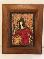 Full view of the framed painting showing a woman in a red dress and black hat.