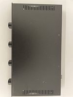 Top view showing flat black metal casing with ventilation slots and control knobs on side.