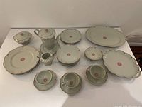Full set of Theodore Haviland Limoges china arranged on flat surface showcasing plates, cups, and serving pieces.
