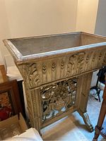 Front view of rectangular wood planter with carved acanthus leaf and wheat motif on decorative stand